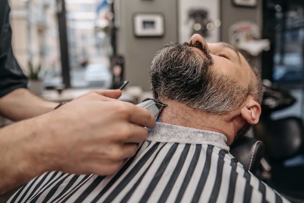 Close-up of a professional barber trimming a mans beard in a stylish barbershop.
